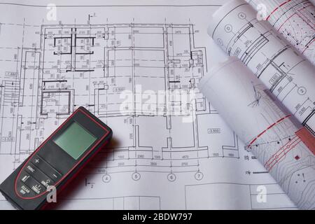 Lasermeter und Zeichnungen am Arbeitsplatz des Ingenieurs. Stockfoto