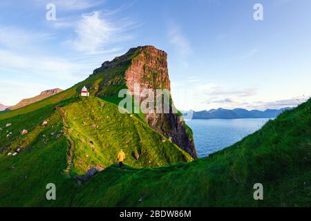 Kallur Leuchtturm auf grünen Hügeln der Insel Kalsoy, Färöer, Dänemark. Landschaftsfotografie Stockfoto