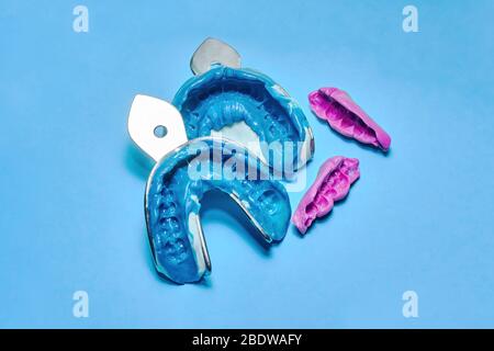 Zwei Zahnabdrücke auf weißem und blauem Hintergrund. Der Aufdruck der Zahnreihe von hochpräzisen und beißenden Registerstücken Stockfoto