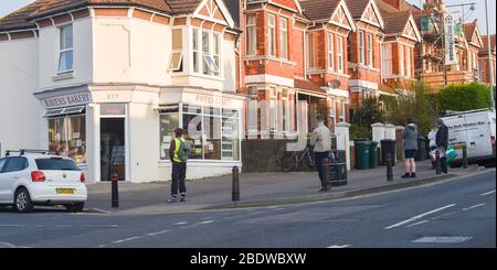 Brighton UK 10. April 2020 - die Käufer stehen am Karfreitagmorgen früh in der Ravens Bakery in Brighton an, wo sie für ihre heißen Brötchen berühmt sind. Die Regierung hat der Öffentlichkeit gesagt, während des Coronavirus COVID-19 Pandemiekrise am Osterwochenende nicht zu gehen. Quelle: Simon Dack / Alamy Live News Stockfoto