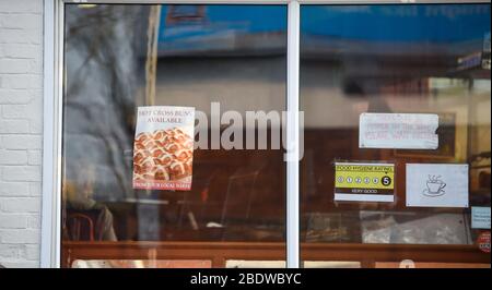 Brighton UK 10. April 2020 - die Käufer stehen am Karfreitagmorgen früh in der Ravens Bakery in Brighton an, wo sie für ihre heißen Brötchen berühmt sind. Die Regierung hat der Öffentlichkeit gesagt, während des Coronavirus COVID-19 Pandemiekrise am Osterwochenende nicht zu gehen. Quelle: Simon Dack / Alamy Live News Stockfoto