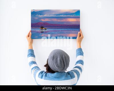 Mädchen hängen weiße Leinwand an der Wand Stockfoto