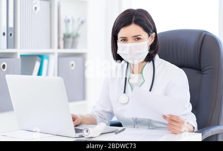 Arzt in medizinischen Gesichtsmaske bei der Arbeit Stockfoto