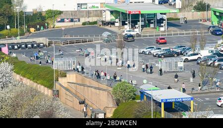 Brighton UK 10. April 2020 - die Käufer stehen am Karfreitagmorgen früh am Parkplatz des Asda Supermarktes in Hollingbury Brighton an. Die Regierung hat der Öffentlichkeit gesagt, nicht über das Osterwochenende zu gehen, trotz der Vorhersage gutes Wetter während der Coronavirus COVID-19 Pandemie-Krise . Quelle: Simon Dack / Alamy Live News Stockfoto