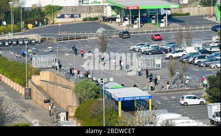 Brighton UK 10. April 2020 - die Käufer stehen am Karfreitagmorgen früh am Parkplatz des Asda Supermarktes in Hollingbury Brighton an. Die Regierung hat der Öffentlichkeit gesagt, nicht über das Osterwochenende zu gehen, trotz der Vorhersage gutes Wetter während der Coronavirus COVID-19 Pandemie-Krise . Quelle: Simon Dack / Alamy Live News Stockfoto