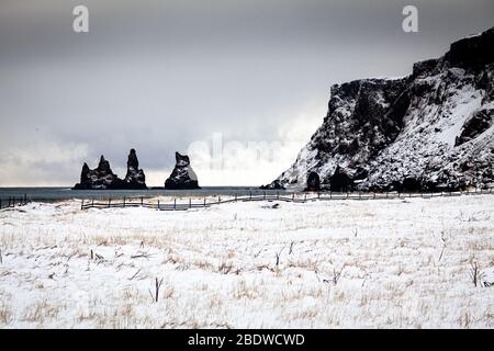 Reynisdrangar Basaltfelsen und Reynisfjall im Winter schneebedeckte Klippen in Vík í Mýrdal an der Südküste Islands Stockfoto