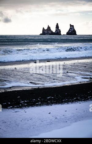 Reynisdrangar Basaltfelsen und Reynisfjall im Winter schneebedeckte Klippen in Vík í Mýrdal an der Südküste Islands Stockfoto
