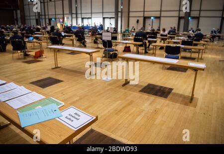 09. April 2020, Sachsen, Dresden: Ein Zettel mit der Aufschrift "Bitte halten Sie Abstand" wird während einer Sondersitzung des Sächsischen Landtags im Internationalen Congress Centrum ICC auf einen Tisch gestellt. Erstmals seit 1993 wird der Landtag nicht mehr in seinem offiziellen Plenarsaal Tagen. Auf der Tagesordnung stehen unter anderem die Erklärung einer "außerordentlichen Notlage" nach Artikel 95 der Sächsischen Staatsverfassung und die Diskussion über die Gesetzesentwürfe der Landesregierung zur Einrichtung eines Sonderfonds "Sächsischer Sabilisierungsfonds" sowie ein ergänzender Stockfoto