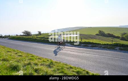 Brighton UK 10. April 2020 - EIN einstrallender Radfahrer in Ditchling Beacon ein bekannter Schönheitsort entlang des South Downs Way in der Nähe von Brighton, wo die Polizei den Parkplatz geschlossen hat. Die Regierung hat der Öffentlichkeit gesagt, nicht über das Osterwochenende zu gehen, trotz der Vorhersage gutes Wetter während der Coronavirus COVID-19 Pandemie-Krise . Quelle: Simon Dack / Alamy Live News Stockfoto