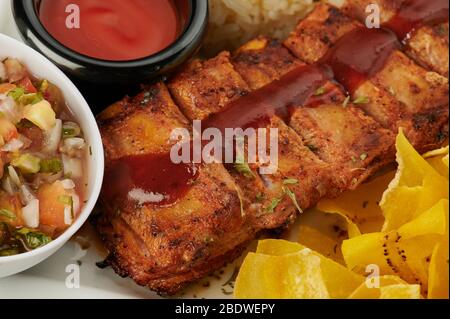 Nahaufnahme von Grillrippchen mit Tomatensauce und Salsa Stockfoto