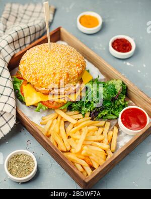 Hähnchenburger mit pommes frites auf Holzbrett Stockfoto