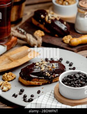 Chocolate eclair mit Schokolade und geriebenen Nüssen beschichtet Stockfoto