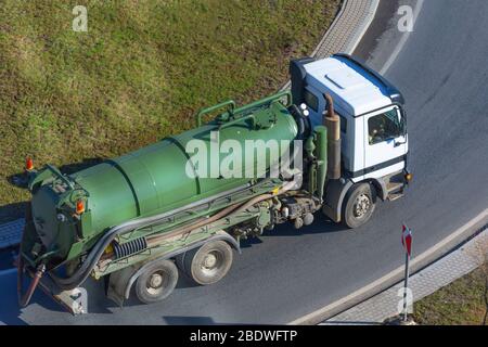 LKW mit grünem Tank zum Pumpen von Abfall oder verunreinigtem Wasser Stockfoto