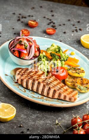 Gebratener Lachs mit Gemüse auf dem Tisch     Stockfoto