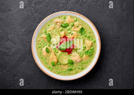 Thai Green Curry mit Huhn oder Gaeng Kaew Wan Gai in weißer Schale auf schwarzem Schiefer Hintergrund. Thai Green Curry ist ein thailändisches Gericht mit grünem Lm Stockfoto