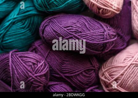 Viele farbige Strickwolle Kugeln Hintergrund. Grün, lila und rosa. Muster. Stockfoto