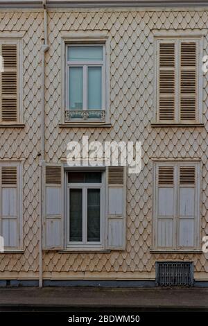 Die dekorativen cremefarbenen Schindeln an der Vorderseite eines traditionellen französischen Hauses in einer Straße in den alten Vororten von Dünkirchen. Stockfoto