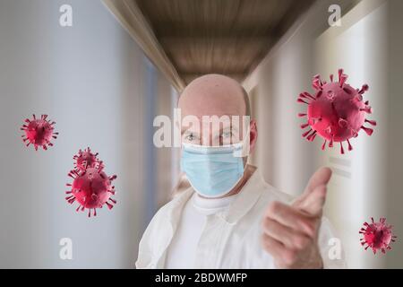 Konzept der Verhinderung der Ausbreitung der Epidemie und Behandlung von Coronavirus: Ein kaukasischer Arzt mit einer Schutzmaske zeigt auf gerenderte Corona-Virus um ihn herum im Korridor eines Krankenhauses. Stockfoto