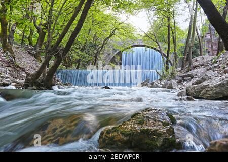 Der Wasserfall von Palaiokaria in Trikala Thessalien Griechenland - steinerne Bogenbrücke zwischen den beiden Wasserfällen Stockfoto