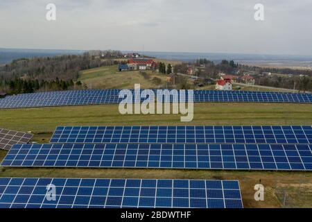Luftaufnahme von blauen Solar-Foto-Voltaic-Paneele-System, das erneuerbare saubere Energie auf ländliche Landschaft produziert Stockfoto