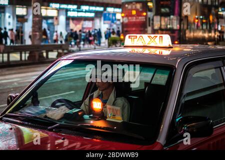 Hongkong, November 2019: Taxi-Wagen wartet in Hongkong in der Nacht Stockfoto