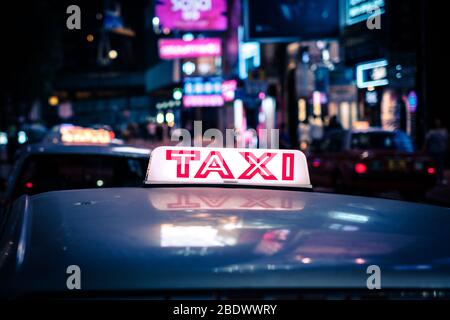 Taxi Schild Taxi Auto in Hong Kong in der Nacht Stockfoto