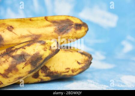 Fauler Teil Bananen auf blauem Hintergrund. Nahaufnahme Stockfoto