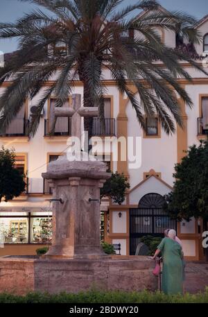 Die Einheimischen stehen an einem Brunnen auf dem Kirchplatz, plaza de la Iglesias, Marbella Altstadt, Spanien. Stockfoto