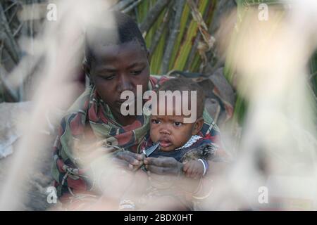 Porträt einer jungen Hadza Mutter mit ihrem Baby, Hadza oder Hadzabe ist ein kleiner Stamm von Jägern Sammler. Fotografiert am Lake Eyasi, Tansania Stockfoto