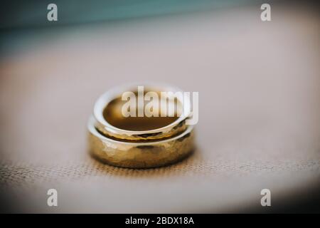 Hochzeit goldene Ringe liegen auf neutralem Hintergrund. Hochzeitsdetails und Dekorationen, Kopierbereich. Stockfoto