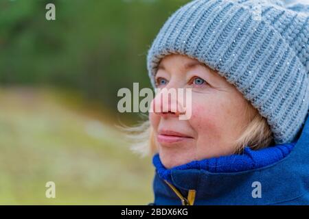 Porträt der glücklichen älteren Frau. Spaziergang im Park. Urlaub im Frühling Urlaubsreise Konzept. Stockfoto