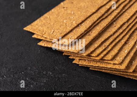 Roggenbrot und Haferflocken mit Koriander und Tmine auf dunklem Grund. Gesunde und umweltfreundliche Lebensmittel. Nahaufnahme Stockfoto