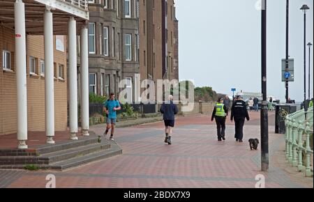 Polizei patrouilliert an einem sehr ruhigen Portobello Strand und Promenade, Edinburgh, Schottland, Großbritannien. April 2020. Im Bild: Polizeipatrouillen auf der Promenade, drei separate vor Mittag innerhalb einer Stunde. Schild sagt Willkommen, aber nicht an diesem Osterwochenende. Stockfoto