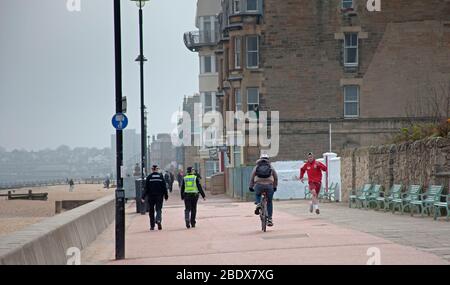 Polizei patrouilliert an einem sehr ruhigen Portobello Strand und Promenade, Edinburgh, Schottland, Großbritannien. April 2020. Im Bild: Polizeipatrouillen auf der Promenade, drei separate vor Mittag innerhalb einer Stunde. Schild sagt Willkommen, aber nicht an diesem Osterwochenende. Stockfoto