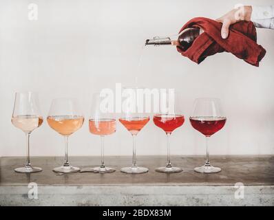 Roséweinschattierungen und Womans Hand Gießen Wein ins Glas Stockfoto