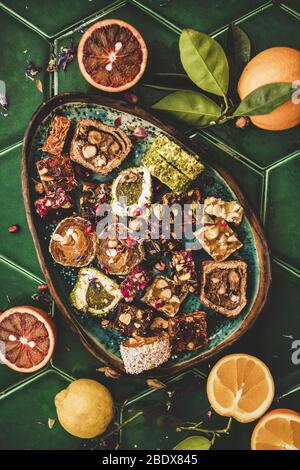 Türkisches traditionelles Lokum und frisches Obst auf dem grünen Fliesentisch Stockfoto