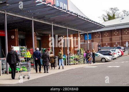 Dundee, Tayside, Schottland, Großbritannien. April 2020. UK Wetter: Lokale Käufer Schlange vor Aldi und Homebargains Läden an einem hellen warmen Karfreitag während der Covid-19 sozialen Distanzierung Lockdown in Dundee. Quelle: Dundee Photographics/Alamy Live News Stockfoto