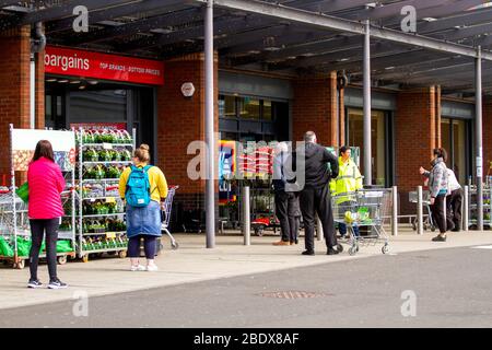 Dundee, Tayside, Schottland, Großbritannien. April 2020. UK Wetter: Lokale Käufer Schlange vor Aldi und Homebargains Läden an einem hellen warmen Karfreitag während der Covid-19 sozialen Distanzierung Lockdown in Dundee. Quelle: Dundee Photographics/Alamy Live News Stockfoto