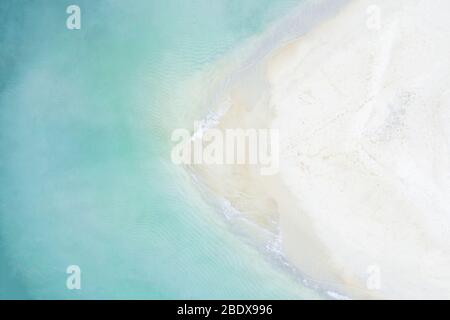 Blick von oben, atemberaubende Luftaufnahme eines weißen Sandstrandes, der von einem wunderschönen türkisfarbenen Meer gebadet wird. Tanjung Aan Beach, östlich von Kuta Lombok, Indonesien. Stockfoto