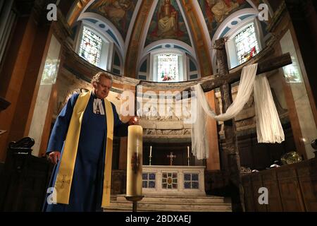 Am 0001. April 11 verhängt, zündet der Pfarrer Peter Sutton die Osterkerze an, während er die Ostersonntagspredigt im Hauptheiligtum der Pfarrkirche St. Cuthbert in Edinburgh aufzeichnet, Die Kirche hat Predigten gestreamt, während Großbritannien weiterhin in der Sperre bleibt, um die Ausbreitung des Coronavirus einzudämmen. Stockfoto