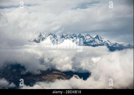 Luftaufnahme von Coronet Peak, The Remarkables, Neuseeland. Die Wolken teil Berggipfel und Blick auf das Tal zu offenbaren. Stockfoto