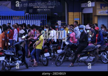 Keine soziale Distanz, Chaos, da kambodschanische Arbeiter in der Bekleidungsfabrik am 1. Tag vor dem kambodschanischen Neujahr während der Coronavirus-Pandemie an einer Bank anstehen Phnom Penh schließt alle Straßen in und aus der Stadt. Phnom Penh, Kambodscha. April 2020. © Kraig Lieb Stockfoto