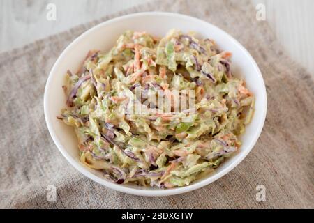 Selbstgemachte cremige Broccoli-Slaw in einer weißen Schüssel, Seitenansicht. Nahaufnahme. Stockfoto