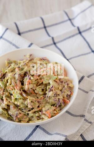 Hausgemachte cremige Broccoli Slaw in einer weißen Schüssel auf Tuch, niedrigen Winkel Ansicht. Kopierbereich. Stockfoto