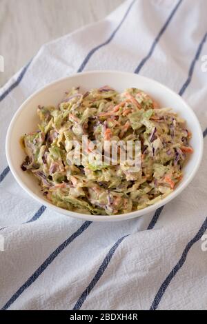 Hausgemachte cremige Broccoli Slaw in einer weißen Schüssel auf Tuch, niedrigen Winkel Ansicht. Stockfoto