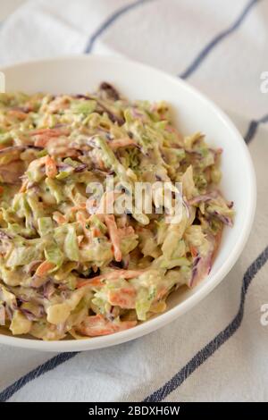 Hausgemachte cremige Broccoli Slaw in einer weißen Schüssel auf Tuch, niedrigen Winkel Ansicht. Nahaufnahme. Stockfoto