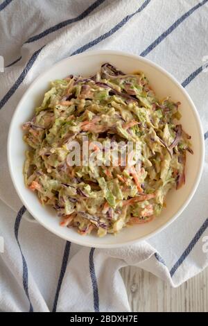 Hausgemachte cremige Broccoli Slaw in einer weißen Schüssel auf Tuch, Draufsicht. Flach liegend, überkopfstehend, von oben. Nahaufnahme. Stockfoto