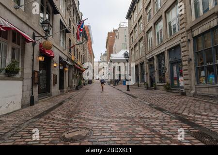 Montreal, Quebec, Kanada -- 28. November 2019. Ein Weitwinkelfoto einer meist leeren Kopfsteinpflasterstraße in Montreal an einem kalten Wintertag. Stockfoto