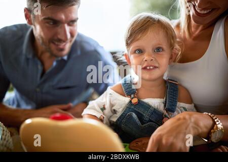 Niedliche weibliche Kind mit Eltern zusammen genießen Stockfoto