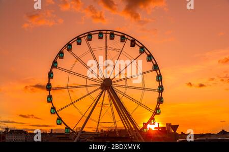 Riesenrad bei Sonnenuntergang, buntes Himmel und Riesenrad. Stockfoto